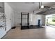 A bright and clean garage space with an open door, gym equipment, and epoxy floor at 1542 Ormond Ter, Parrish, FL 34219
