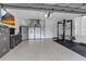 Spacious garage featuring epoxy floors, workout equipment and a TV for entertainment at 1542 Ormond Ter, Parrish, FL 34219
