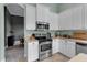Kitchen features stainless appliances, granite counters, tile floors, and flows into the dining area at 1542 Ormond Ter, Parrish, FL 34219