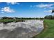 Scenic lake view reflecting the blue sky, surrounded by green grass and beautiful homes at 1542 Ormond Ter, Parrish, FL 34219