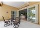 Covered lanai with outdoor dining set, offering views of the living room through sliding glass doors at 1542 Ormond Ter, Parrish, FL 34219