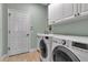 Spacious laundry room featuring white cabinets and a modern washer and dryer at 1542 Ormond Ter, Parrish, FL 34219