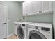 Bright laundry room with modern washer/dryer set and cabinetry at 1542 Ormond Ter, Parrish, FL 34219