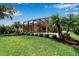 Inviting backyard oasis with screened-in pool, lush landscaping, and sunny lawn at 1542 Ormond Ter, Parrish, FL 34219