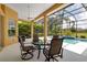 Covered lanai with a view of the screened-in pool and well-maintained landscaping at 1542 Ormond Ter, Parrish, FL 34219