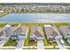 Aerial view of homes with solar, surrounding pond, showcases the community's layout and access to natural light and water views at 16746 Parker River St, Wimauma, FL 33598