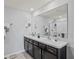 Modern bathroom featuring a double vanity, stylish fixtures, and a large mirror at 16746 Parker River St, Wimauma, FL 33598