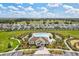 Aerial view of community pool, clubhouse, and playground in a well-manicured neighborhood with plenty of green space at 16746 Parker River St, Wimauma, FL 33598