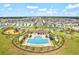 Aerial view showcases pool, playground, with view of long roadway for the neighborhood at 16746 Parker River St, Wimauma, FL 33598