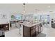 Open-concept kitchen with island, adjacent to living room and dining area at 16746 Parker River St, Wimauma, FL 33598