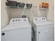 Convenient laundry room equipped with a washer, dryer, and storage shelves at 16746 Parker River St, Wimauma, FL 33598