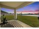 Covered patio with comfortable seating offering a picturesque backyard and lake view at 16746 Parker River St, Wimauma, FL 33598