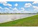 Scenic view of the tranquil pond, offering a serene backdrop to the neighborhood, framed by a bright, sunny sky at 16746 Parker River St, Wimauma, FL 33598