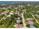 Aerial view showcasing the property's location in a neighborhood surrounded by lush greenery and a serene water feature at 1715 Fossil Dr, Englewood, FL 34223