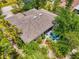 Aerial view of the home highlighting the private patio area, screened lanai, and lush tropical landscaping at 1715 Fossil Dr, Englewood, FL 34223