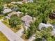 An aerial view of a single-Gathering home featuring a spacious lot with mature trees and a pond at 1715 Fossil Dr, Englewood, FL 34223