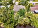 Aerial view of home with lush landscaping, located on water with mature trees in a peaceful residential area at 1715 Fossil Dr, Englewood, FL 34223
