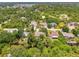 The property is showcased in an aerial shot, nestled among lush greenery and a winding creek at 1715 Fossil Dr, Englewood, FL 34223