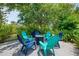 Backyard with seating area around a fire pit, surrounded by lush landscaping and a privacy screen of mature trees at 1715 Fossil Dr, Englewood, FL 34223