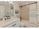Bright bathroom features a shower with a curtain and a single sink vanity with a mirror at 1715 Fossil Dr, Englewood, FL 34223