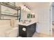 Well-lit bathroom features a double sink vanity, a shelf, and a white toilet at 1715 Fossil Dr, Englewood, FL 34223