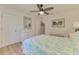 Bright bedroom with wood-look floors, white dresser and a ceiling fan at 1715 Fossil Dr, Englewood, FL 34223