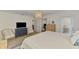 Light and airy bedroom features a TV, two chairs, and access to the outside porch at 1715 Fossil Dr, Englewood, FL 34223