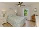Bright bedroom featuring wood-look floors, a ceiling fan, and a charming nautical-themed quilt at 1715 Fossil Dr, Englewood, FL 34223