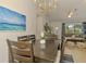 Dining room with a table for six, beach art, and is adjacent to the living room at 1715 Fossil Dr, Englewood, FL 34223