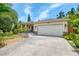 Lovely home featuring a two-car garage, stone accents, and professionally landscaped front yard at 1715 Fossil Dr, Englewood, FL 34223