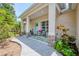 Inviting front porch with decorative columns, a blue door, and outdoor seating at 1715 Fossil Dr, Englewood, FL 34223