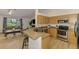 Kitchen with breakfast bar overlooking the living room, featuring wood cabinets and stainless steel appliances at 1715 Fossil Dr, Englewood, FL 34223