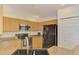 Bright kitchen with stainless steel appliances, wood cabinets, sleek countertops, and an adjacent pantry at 1715 Fossil Dr, Englewood, FL 34223