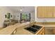 Kitchen with breakfast bar overlooking the living room, featuring wood cabinets and stainless steel appliances at 1715 Fossil Dr, Englewood, FL 34223