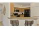 Well-lit kitchen featuring ample wood cabinetry, stainless steel appliances, and a breakfast bar with seating at 1715 Fossil Dr, Englewood, FL 34223