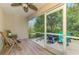 Screened lanai with seating area, offering views of the lush, private backyard at 1715 Fossil Dr, Englewood, FL 34223
