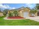 Well-maintained home with two-car garage, mature palm trees, and lush green lawn at 203 28Th W St, Palmetto, FL 34221