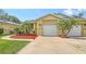 Charming single-story home with a two-car garage, lush landscaping, and a well-maintained lawn at 203 28Th W St, Palmetto, FL 34221