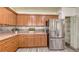 Kitchen with stainless steel appliances, wood cabinets, granite counter, and pantry access at 203 28Th W St, Palmetto, FL 34221