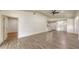 Open-concept living room with modern gray flooring, ceiling fan, and pendant lighting adjacent to the breakfast bar at 203 28Th W St, Palmetto, FL 34221