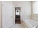 Bright bathroom with soaking tub, tile flooring, and doorway leading into the bedroom at 20316 Natures Corner Dr, Tampa, FL 33647