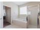 Bright bathroom featuring a garden tub, glass block window, and separate glass-enclosed shower at 20316 Natures Corner Dr, Tampa, FL 33647