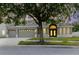 Charming home featuring a well-manicured lawn, a spacious three-car garage, and a welcoming arched entryway at 20316 Natures Corner Dr, Tampa, FL 33647