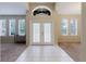 Bright foyer featuring decorative double doors, white tile flooring, and ample natural light from surrounding windows at 20316 Natures Corner Dr, Tampa, FL 33647