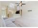 Spacious living room with vaulted ceilings, fan, and view into the entryway and kitchen at 20316 Natures Corner Dr, Tampa, FL 33647