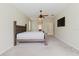 Carpeted main bedroom with fan, window and view to the bathroom entrance at 20316 Natures Corner Dr, Tampa, FL 33647