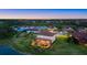 Aerial view of a home with a screened pool, situated on a lush lot with a lake view at 20831 Valprato Ct, Venice, FL 34293