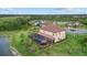 Aerial view of the backyard with a screened in pool, lake view, and surrounding greenery at 20831 Valprato Ct, Venice, FL 34293