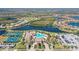 Aerial view of a community showcasing a resort-style pool, tennis courts, and beautiful landscaping at 20831 Valprato Ct, Venice, FL 34293