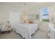 Comfortable bedroom with neutral walls, cozy chair, closet, and a window providing ample natural light at 20831 Valprato Ct, Venice, FL 34293
